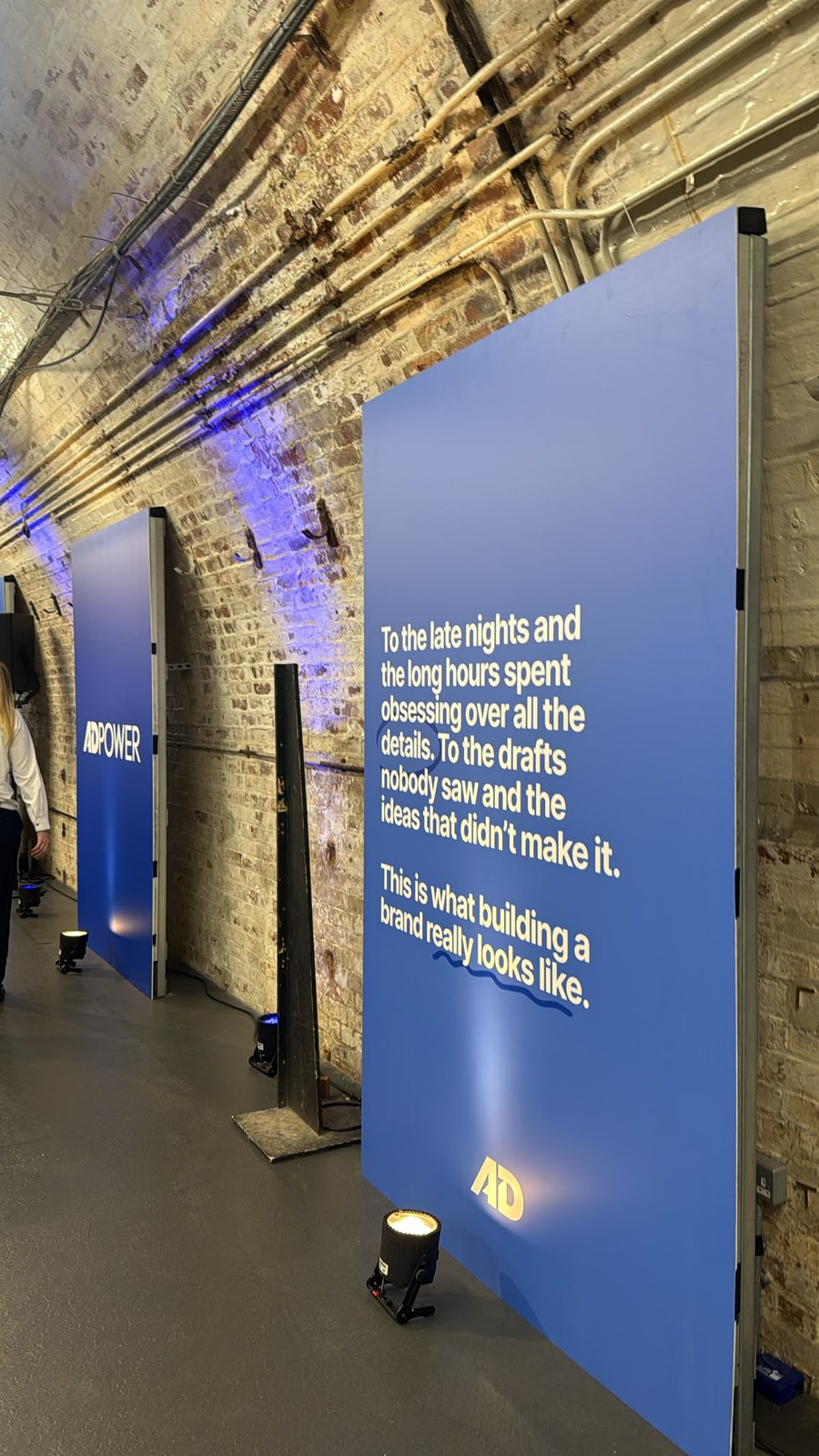 Tall blue AdPower foamex panels standing against the brick wall of the Mail Rail tunnel