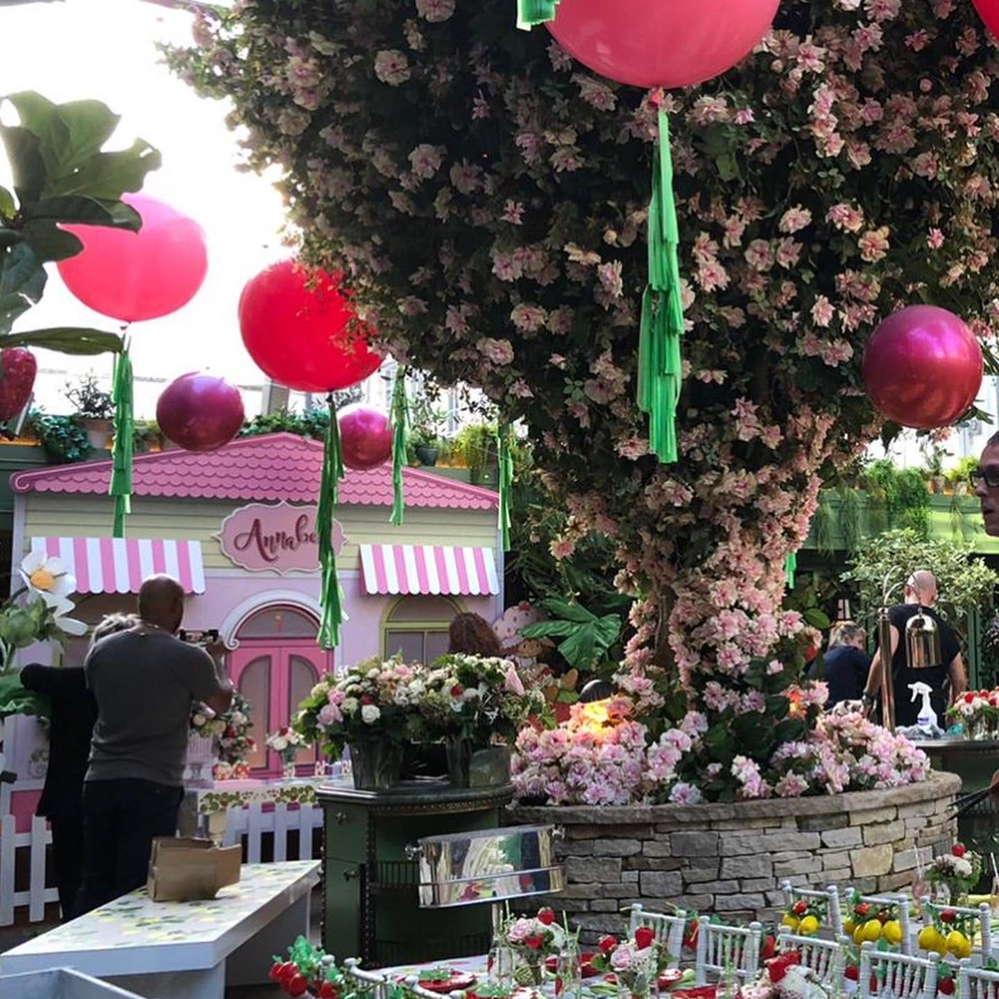 The strawberry garden at Annabel’s, with the storybook house beneath a blossom tree