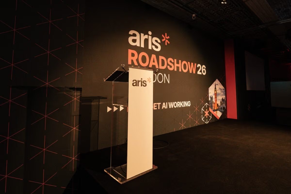 The branded ARIS lectern in front of the Roadshow 26 London wall