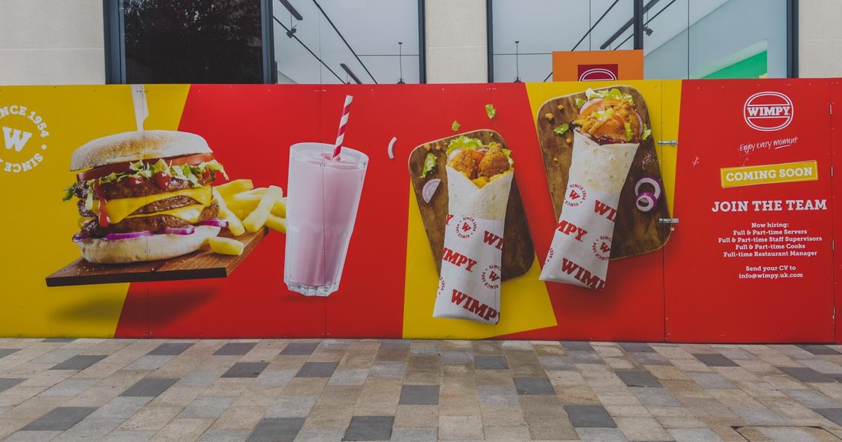 WIMPY coming soon hoarding with a giant burger, milkshake and wraps on red and yellow panels