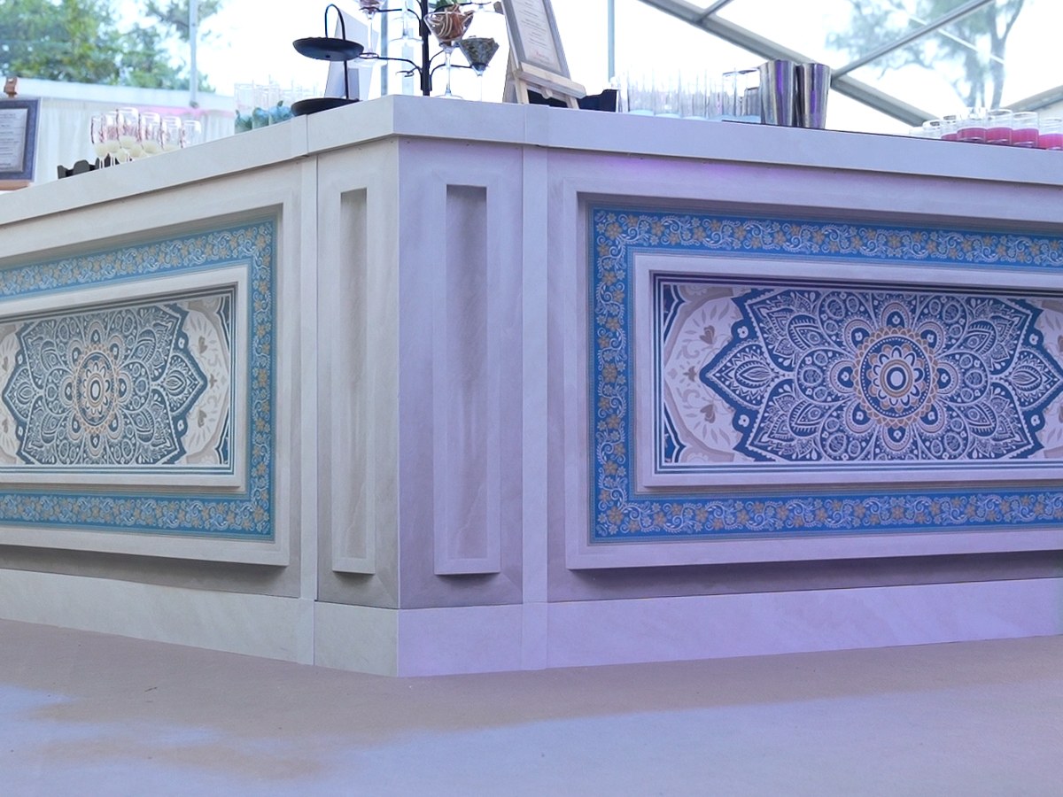 Event bar wrapped in printed blue and gold mandala panels inside a marquee