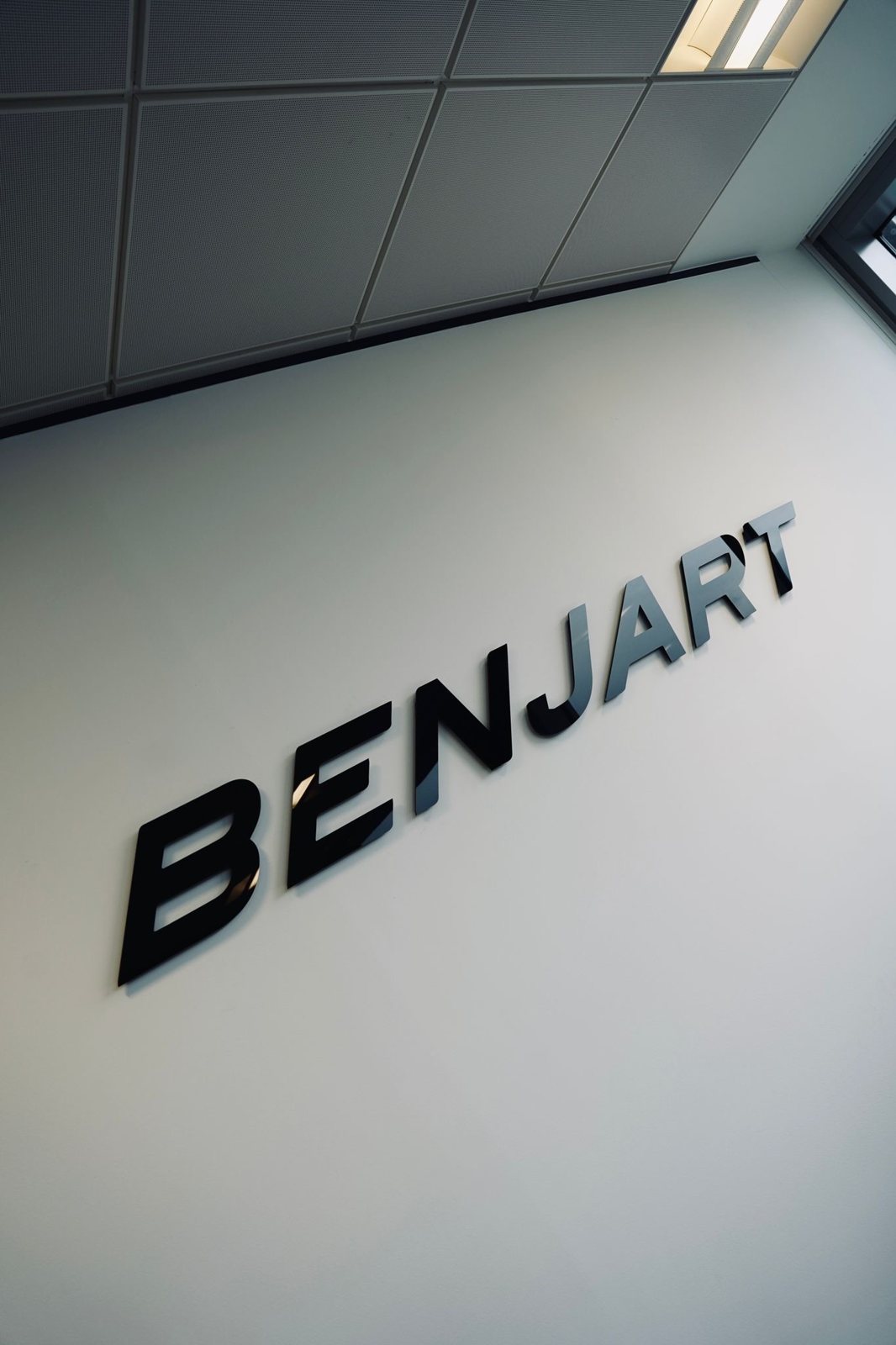 BENJART black gloss acrylic letters catching the light from the windows