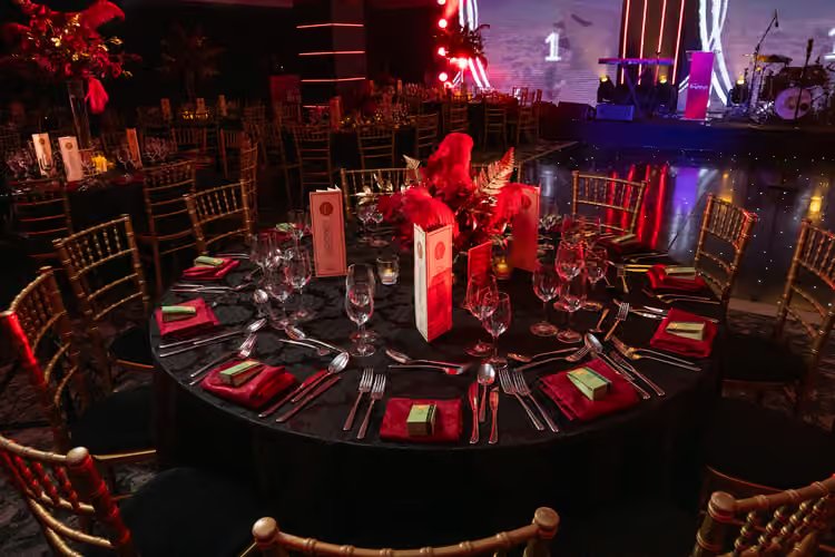 A ballroom dinner table under red lighting