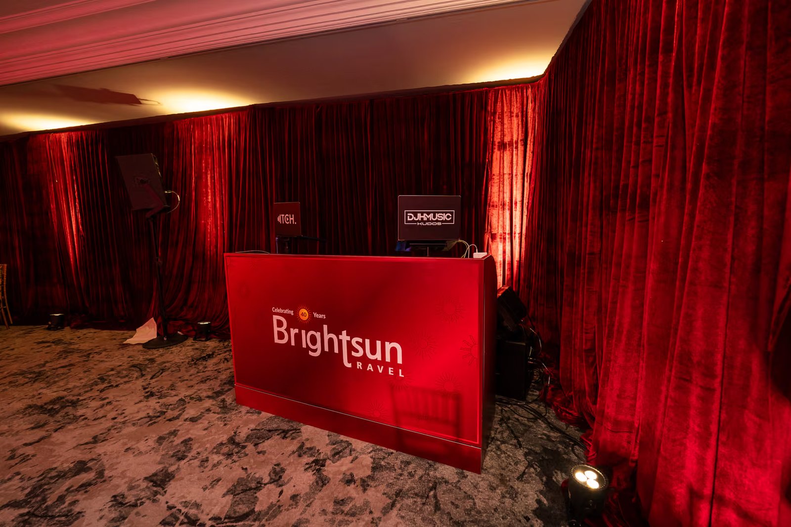The red Brightsun DJ booth against red drapes