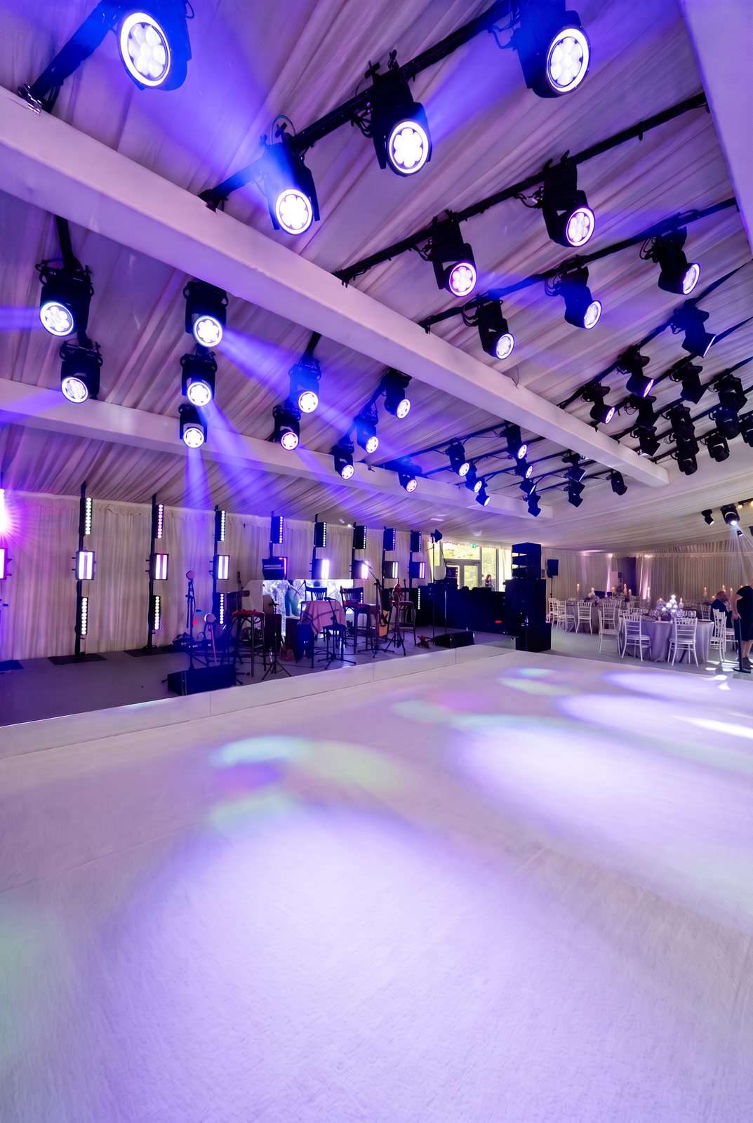 White carpet floor in front of a lit stage with moving head lights in a marquee