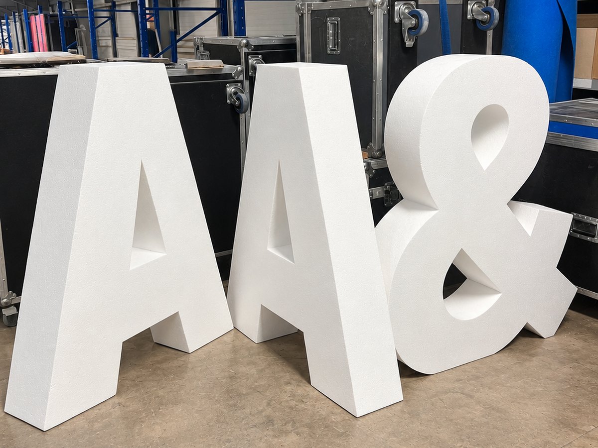 Giant white CNC cut foam letters A, A and an ampersand in the Print Station warehouse