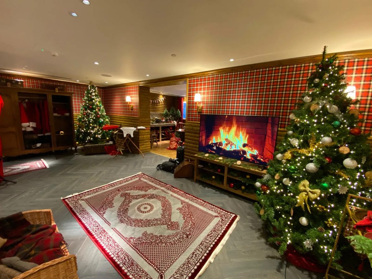 Tartan fireside lounge in the Hilton Santa's grotto log cabin with dressed Christmas trees