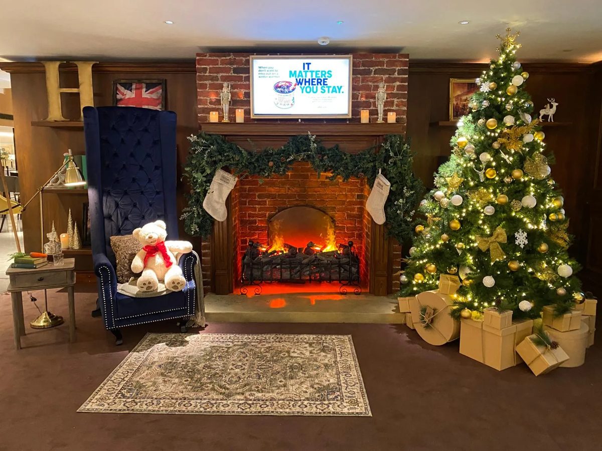 Brick effect fireplace, velvet throne chair and gold Christmas tree