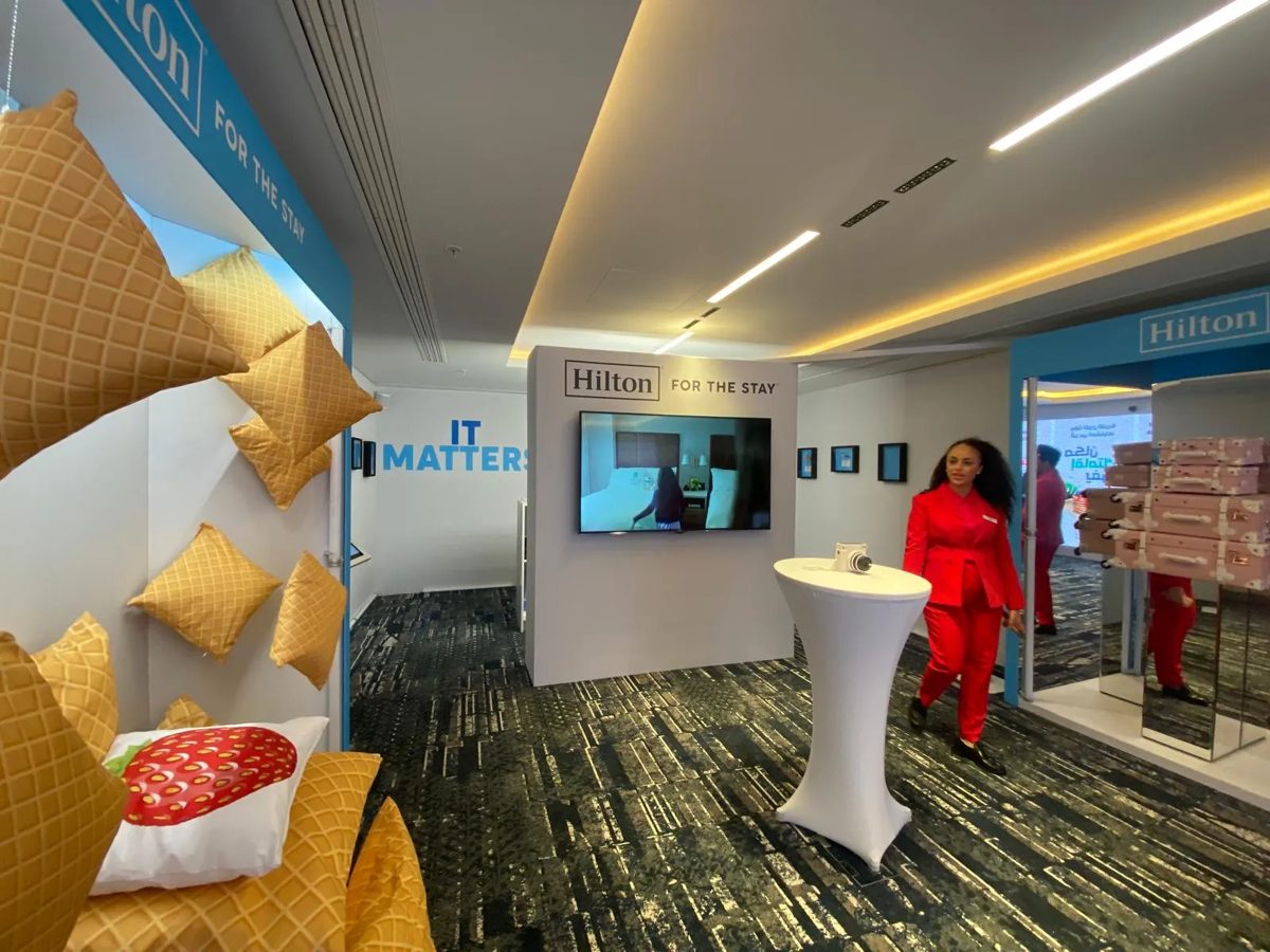 Hilton For The Stay activation with pillow wall, branded TV wall and mirrored suitcase display