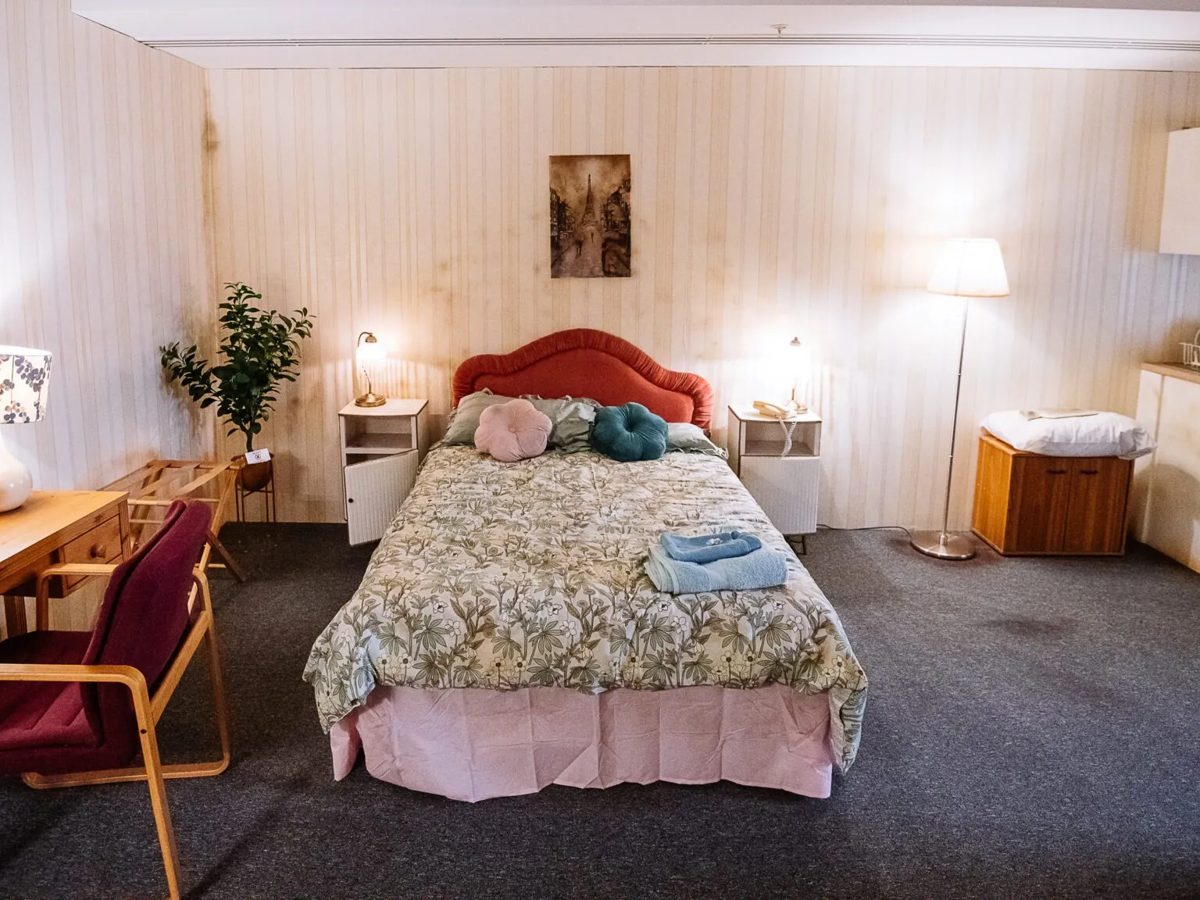 Escape room set of a deliberately dated hotel bedroom with printed wallpaper