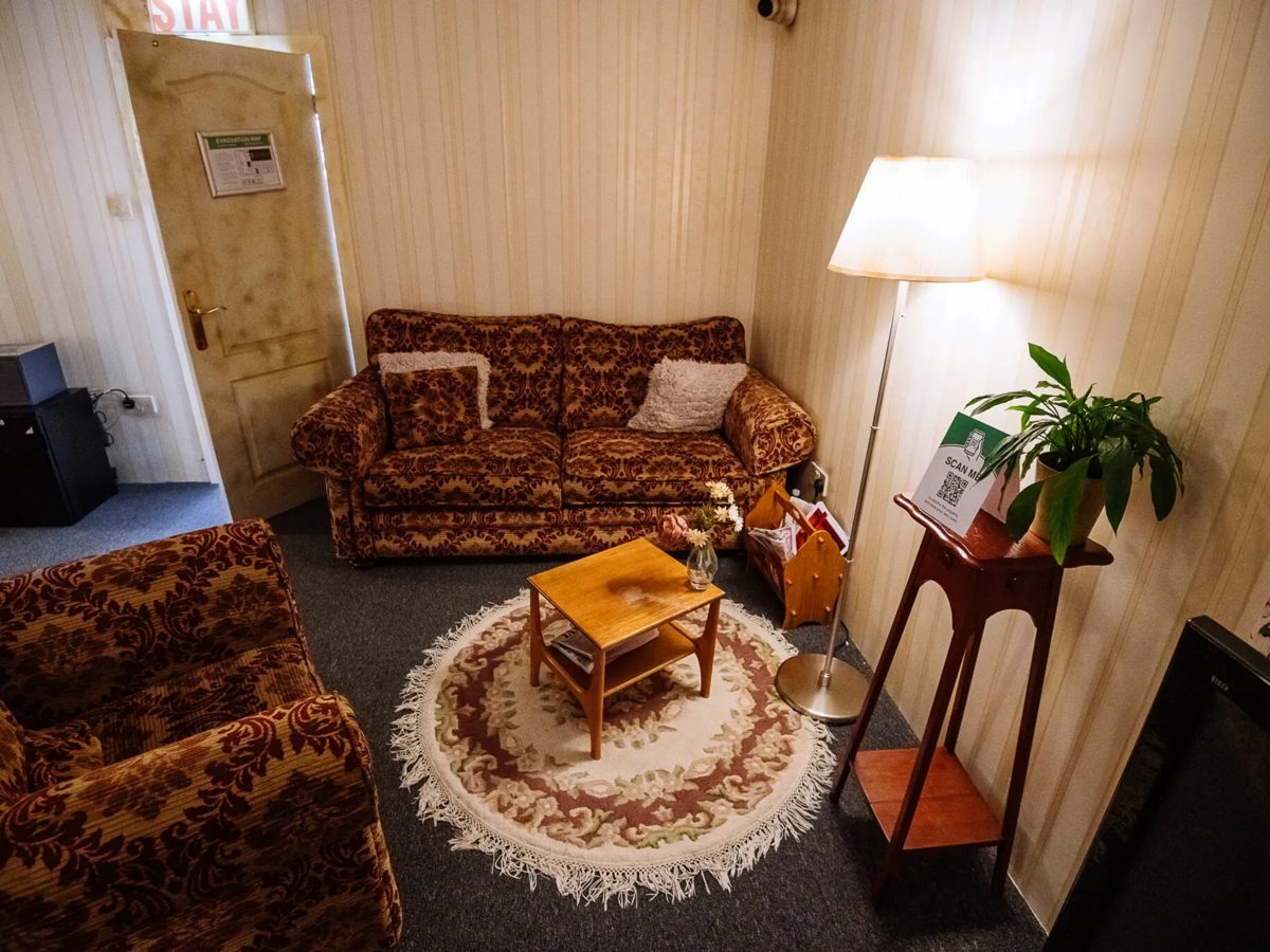 Retro escape room sitting room with patterned sofas and striped wallpaper