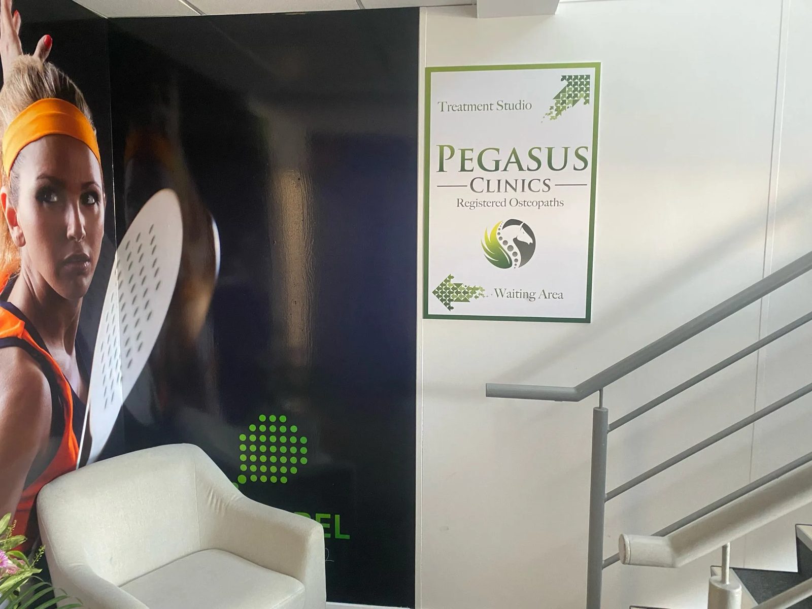 Pegasus directional sign in the stairwell next to the padel wall