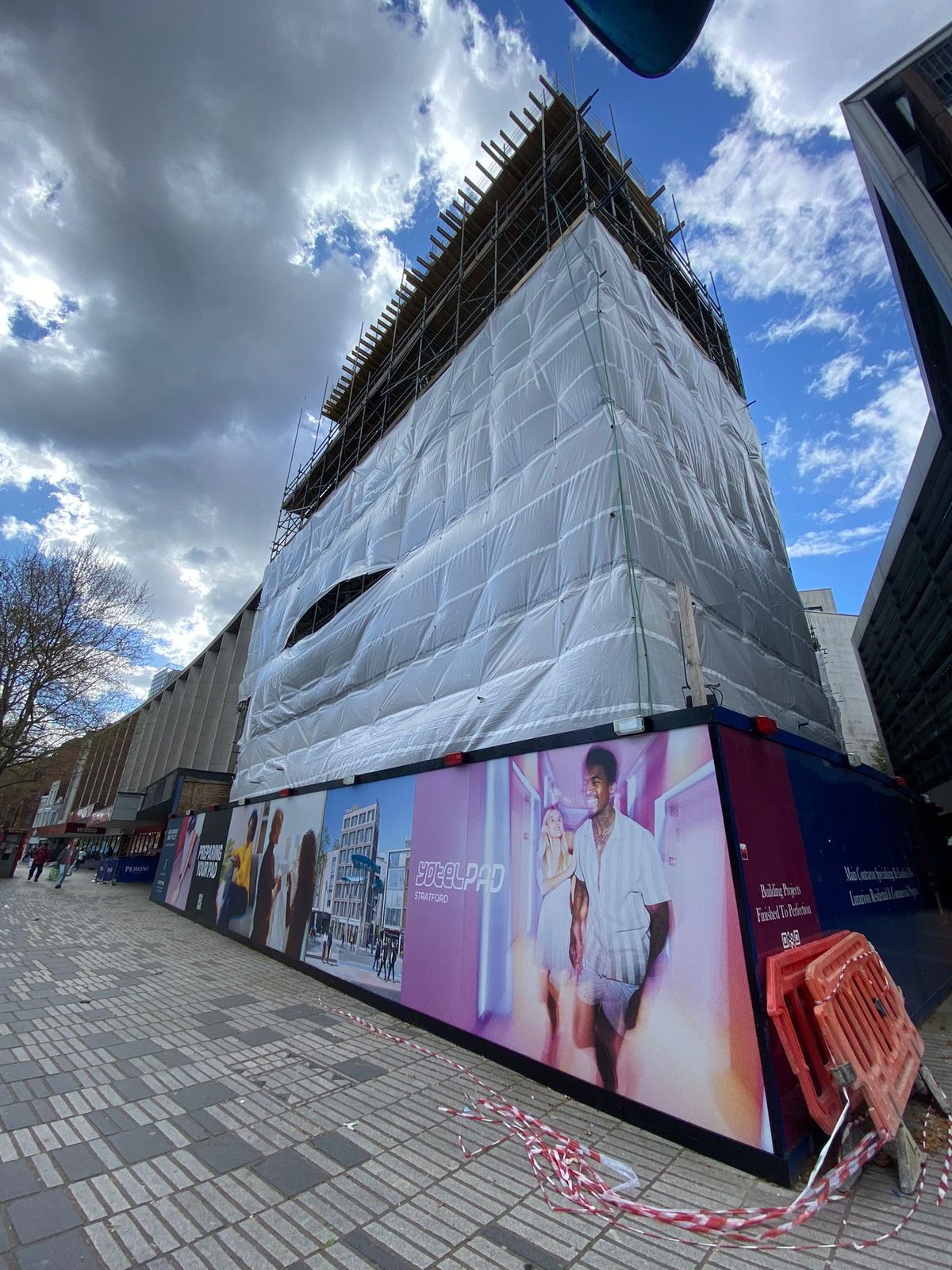 YOTELPAD hoarding at the foot of the wrapped and scaffolded building