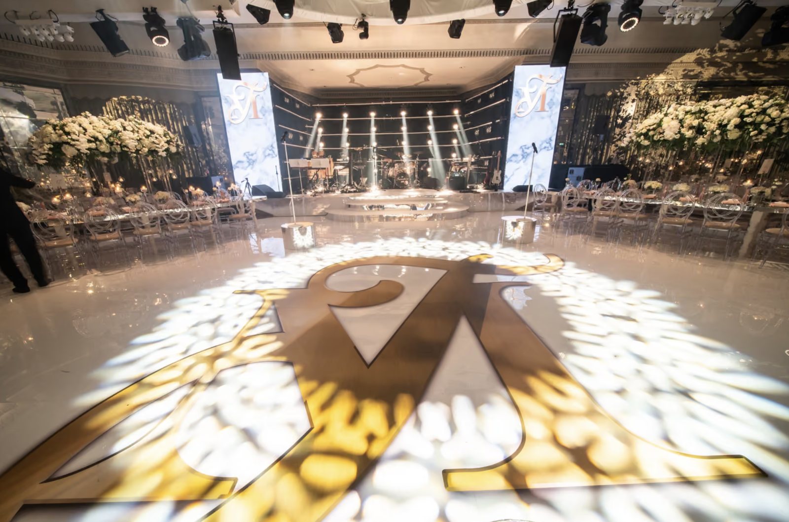 The gloss white dance floor with the couple’s giant gold monogram
