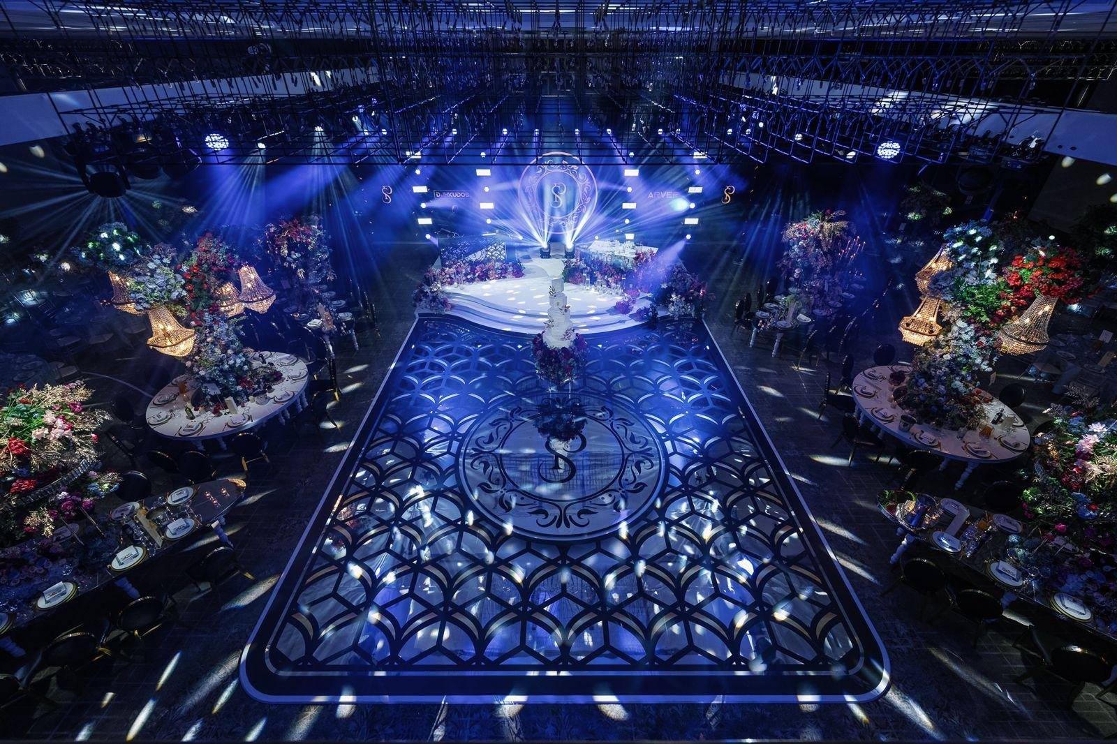 Black and gold monogram and lattice design printed on a silver mirror dance floor at a grand wedding reception