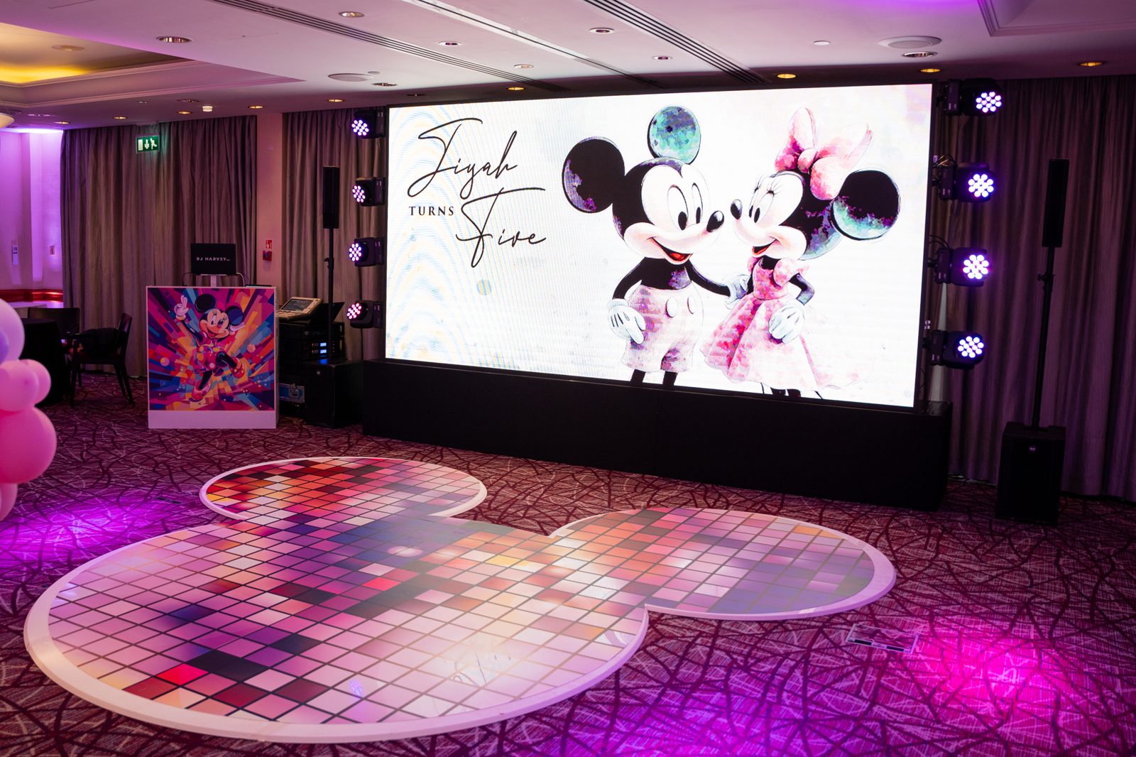 Custom Mickey Mouse ears shaped dance floor with a printed disco tile design at a fifth birthday party