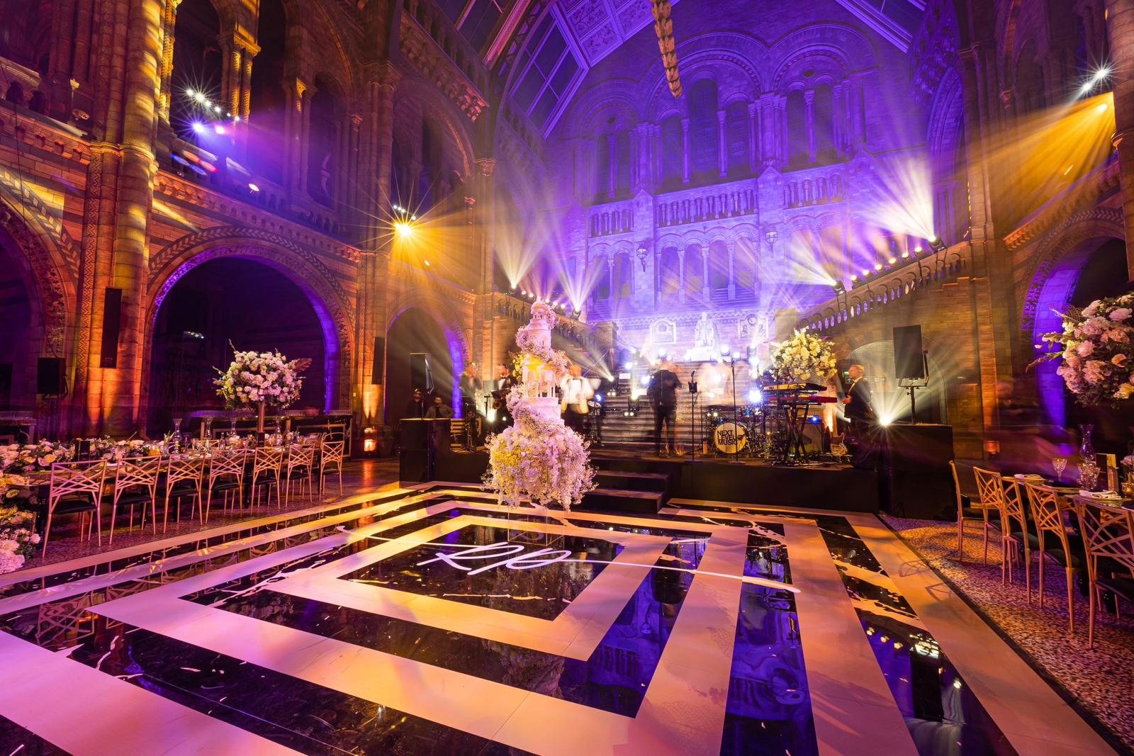 Matt gold gradient design and monogram printed on a piano black dance floor at the Natural History Museum, London