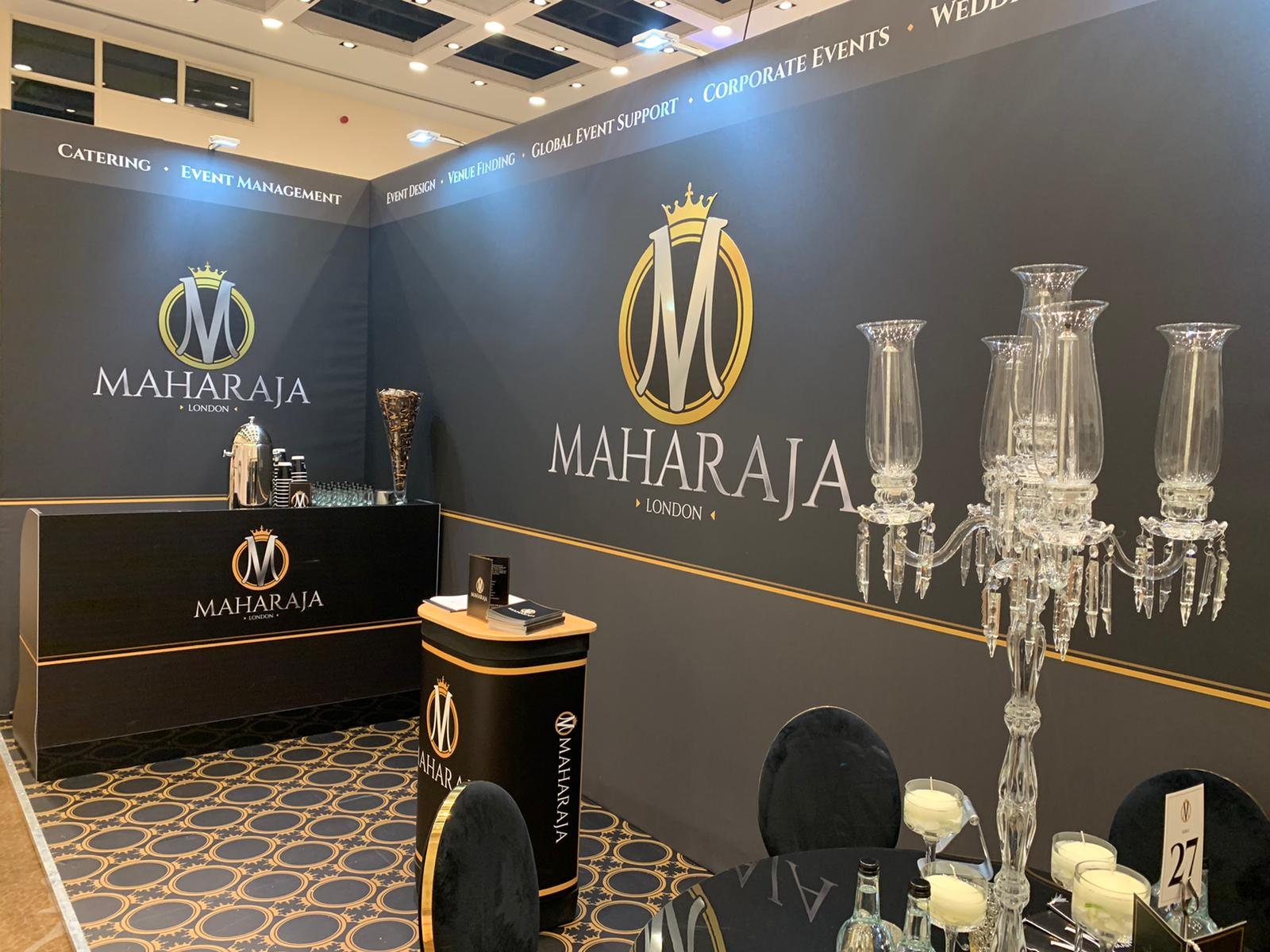 Maharaja London exhibition stand with charcoal and gold canvas wrapped walls, branded counter and podium