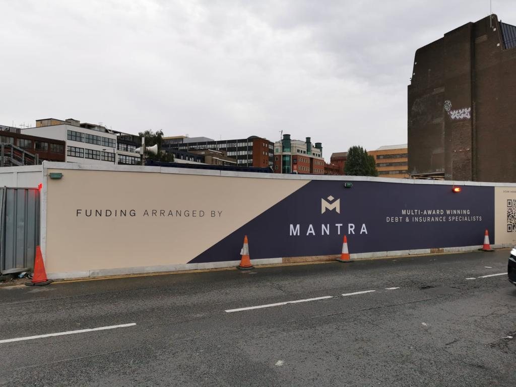 Long cream and navy site hoarding reading Funding arranged by Mantra, multi award winning debt and insurance specialists