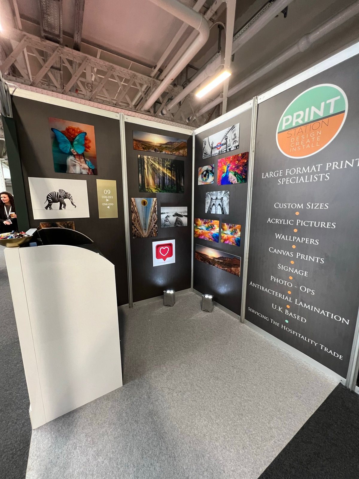 Print Station's own shell scheme stand with charcoal foamex panels displaying acrylic and photo prints