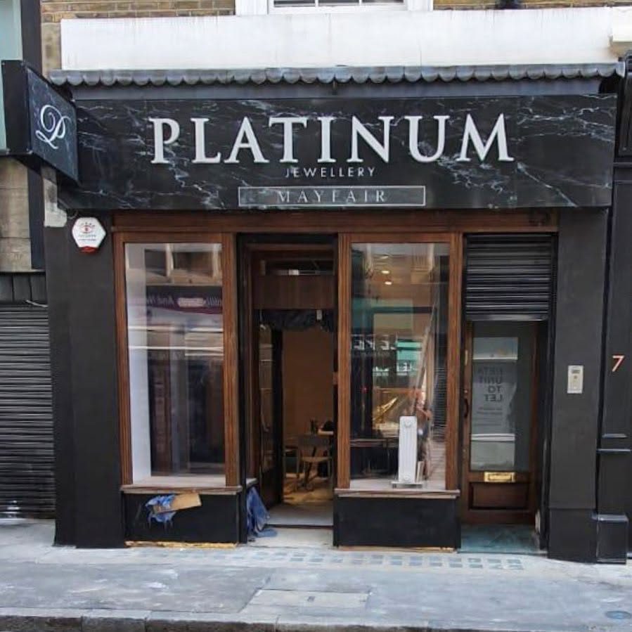 Platinum Jewellery Mayfair shopfront with a black marble effect fascia, raised white lettering and a matching projecting sign