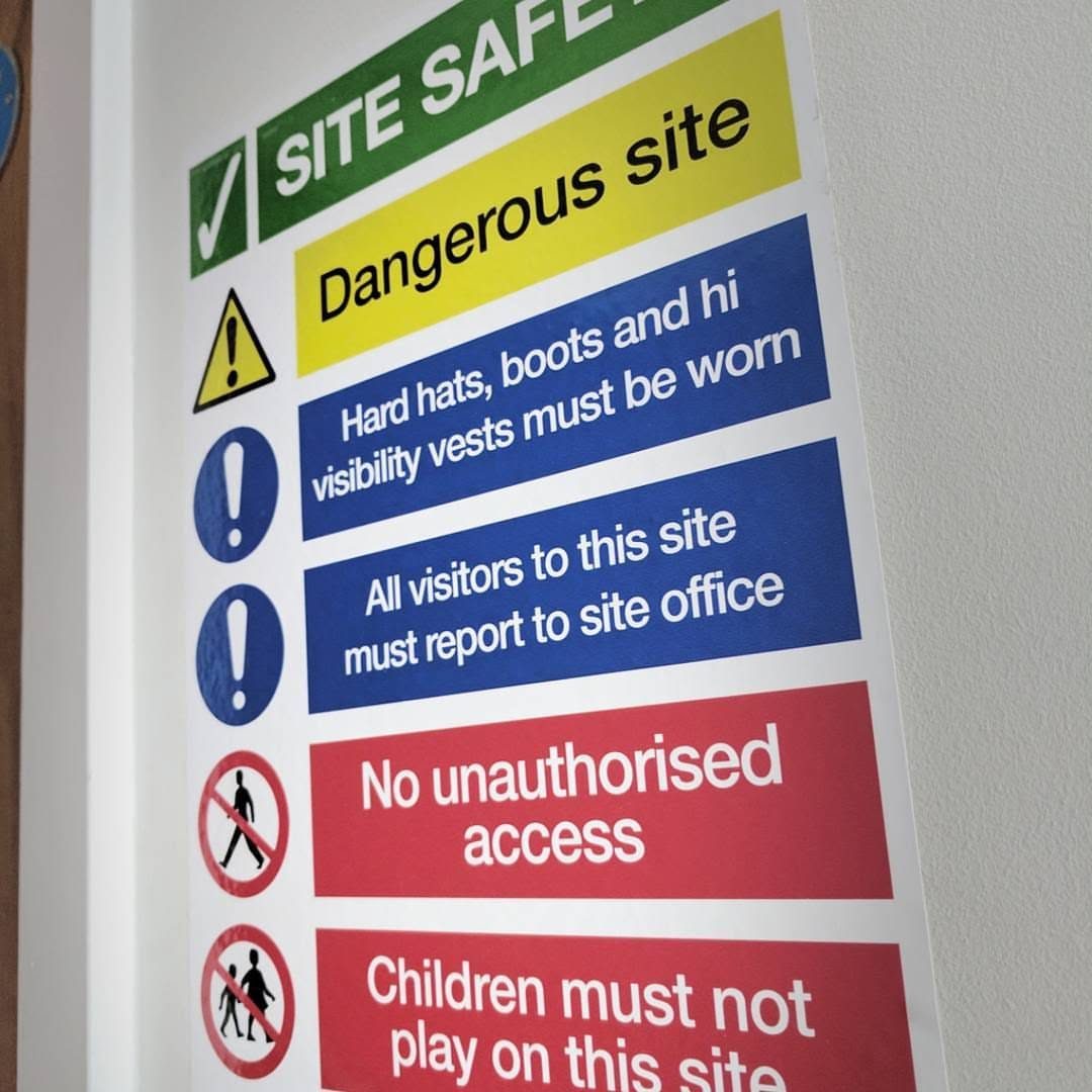 Site safety sign with colour coded panels for dangerous site, hard hats, boots and hi visibility vests, visitors reporting to the site office and no unauthorised access