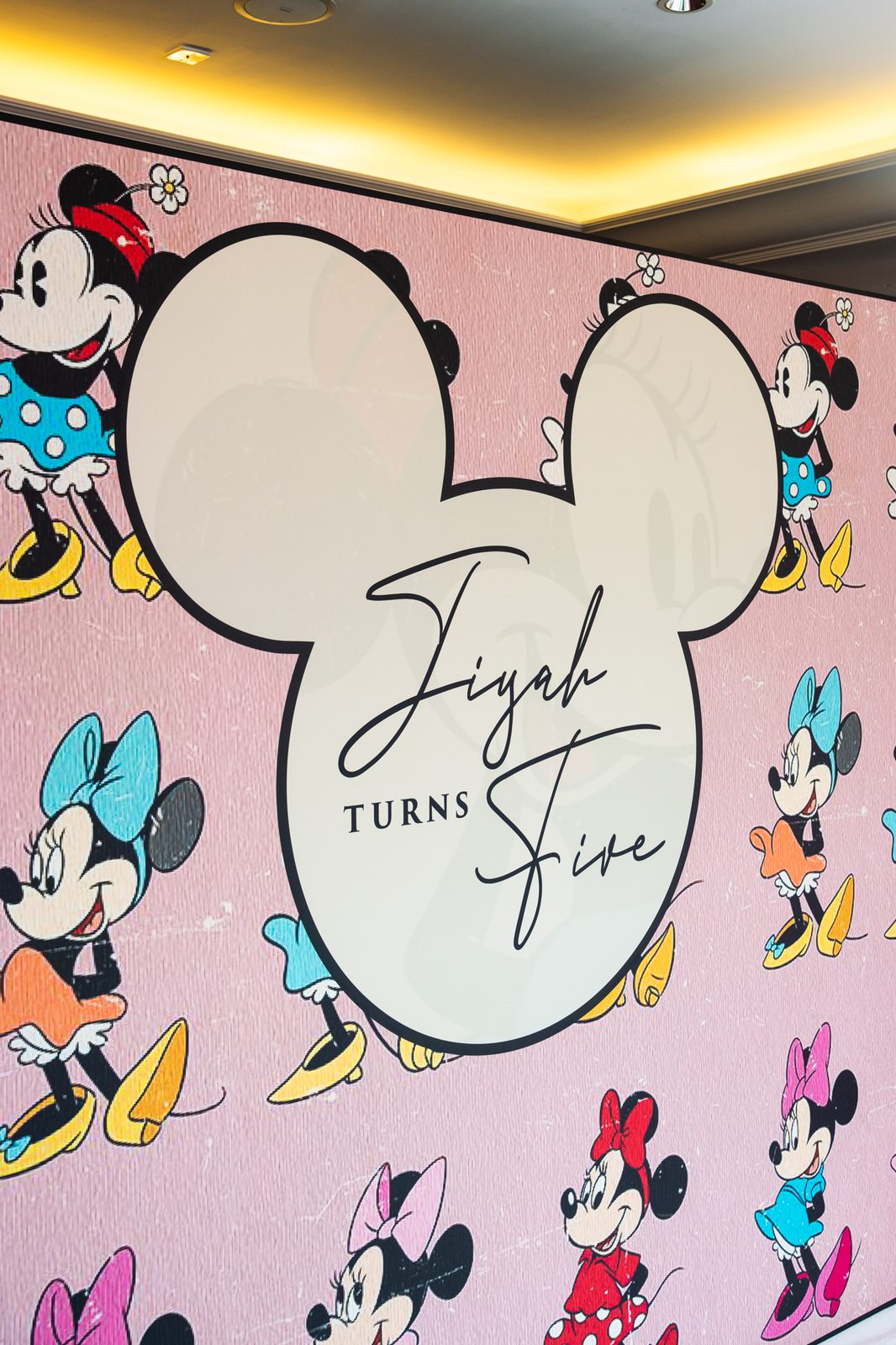 Close up of the Mickey head name panel on Jiyah's printed party backdrop, framed by pink and lilac balloons