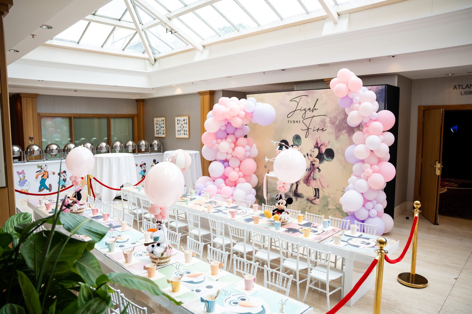 Kids party room dressed in pink and lilac with the printed Mickey and Minnie watercolour backdrop