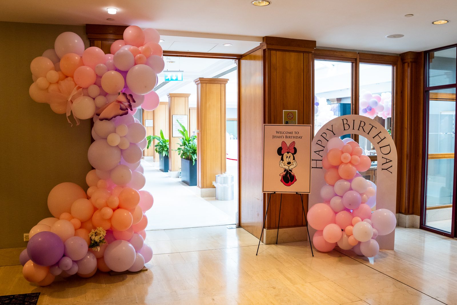 Printed Minnie Mouse welcome board on an easel at the entrance to a kids birthday party