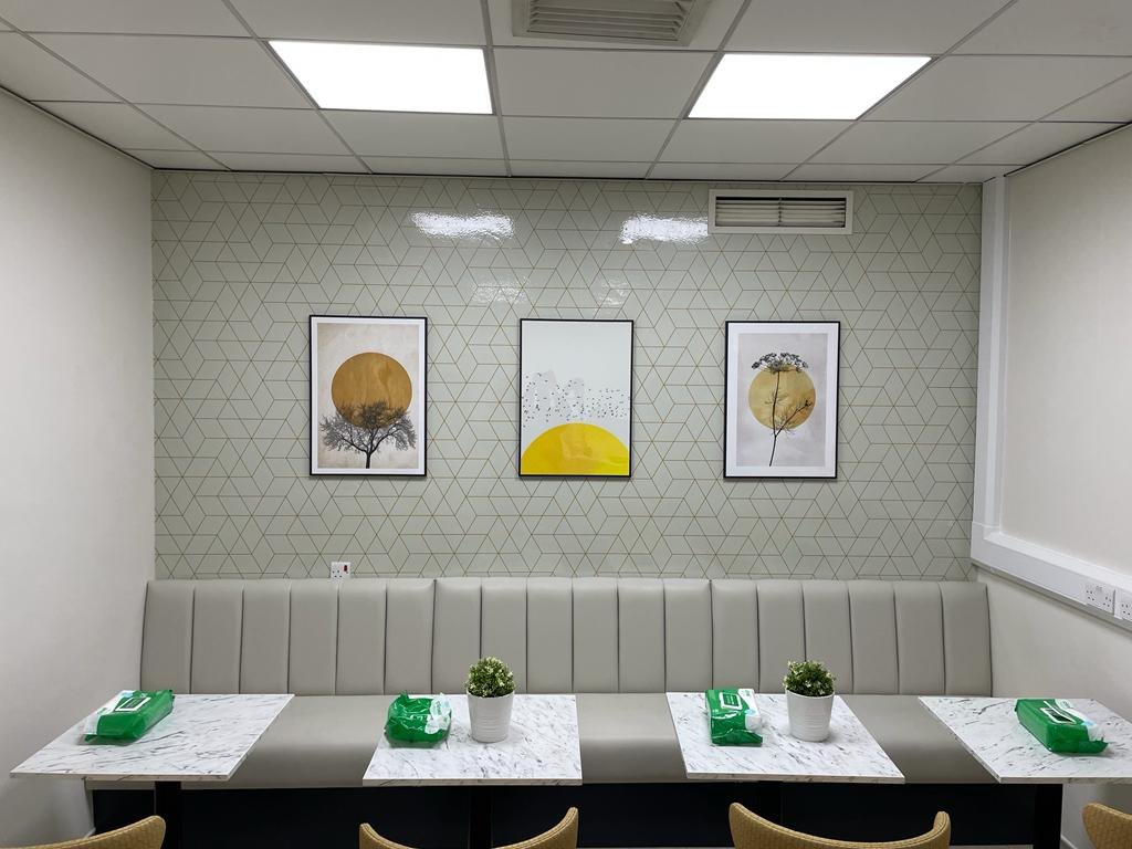 NHS staff breakout room with antibacterial printed geometric wallpaper, banquette seating and marble tables