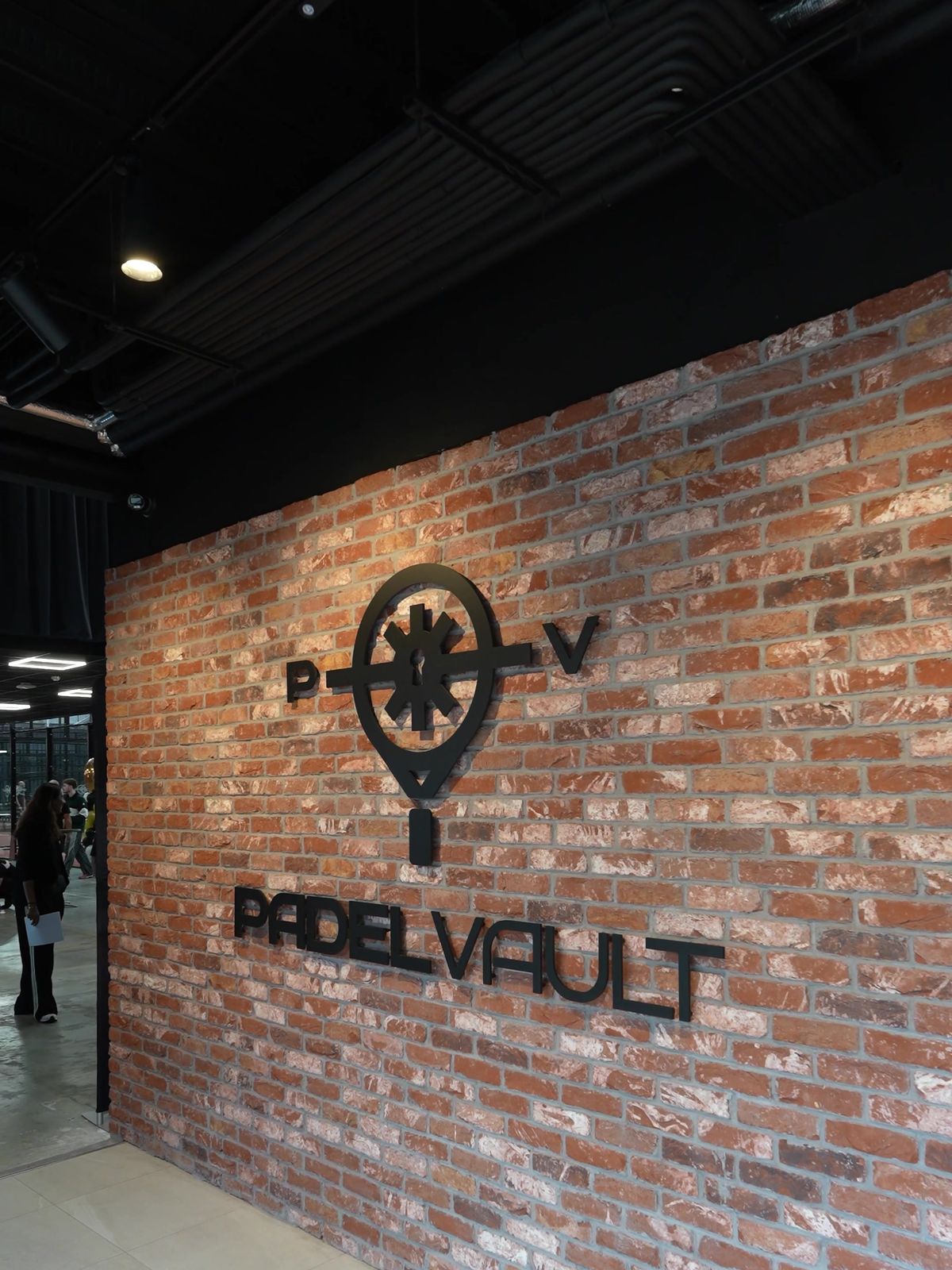 3D Padel Vault logo on the reception brick wall