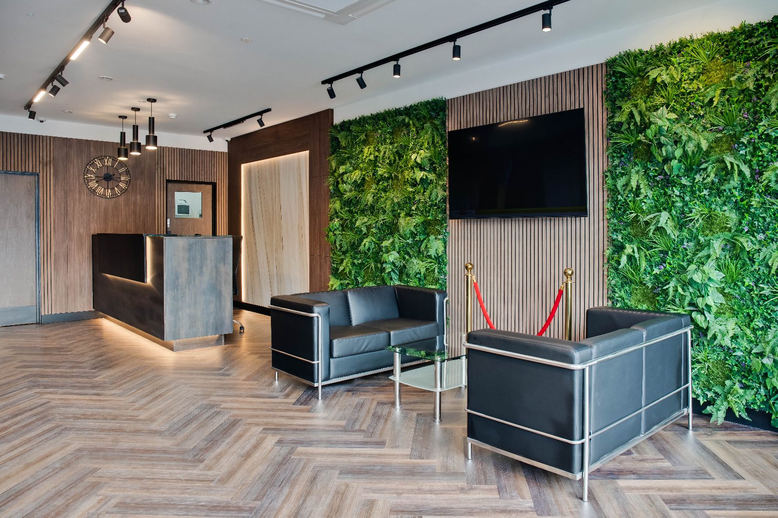 Hotel reception and lounge with slatted timber panels and a living green wall