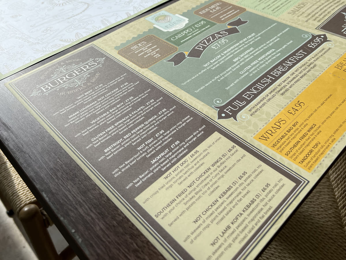Printed café menu placemats on a restaurant table