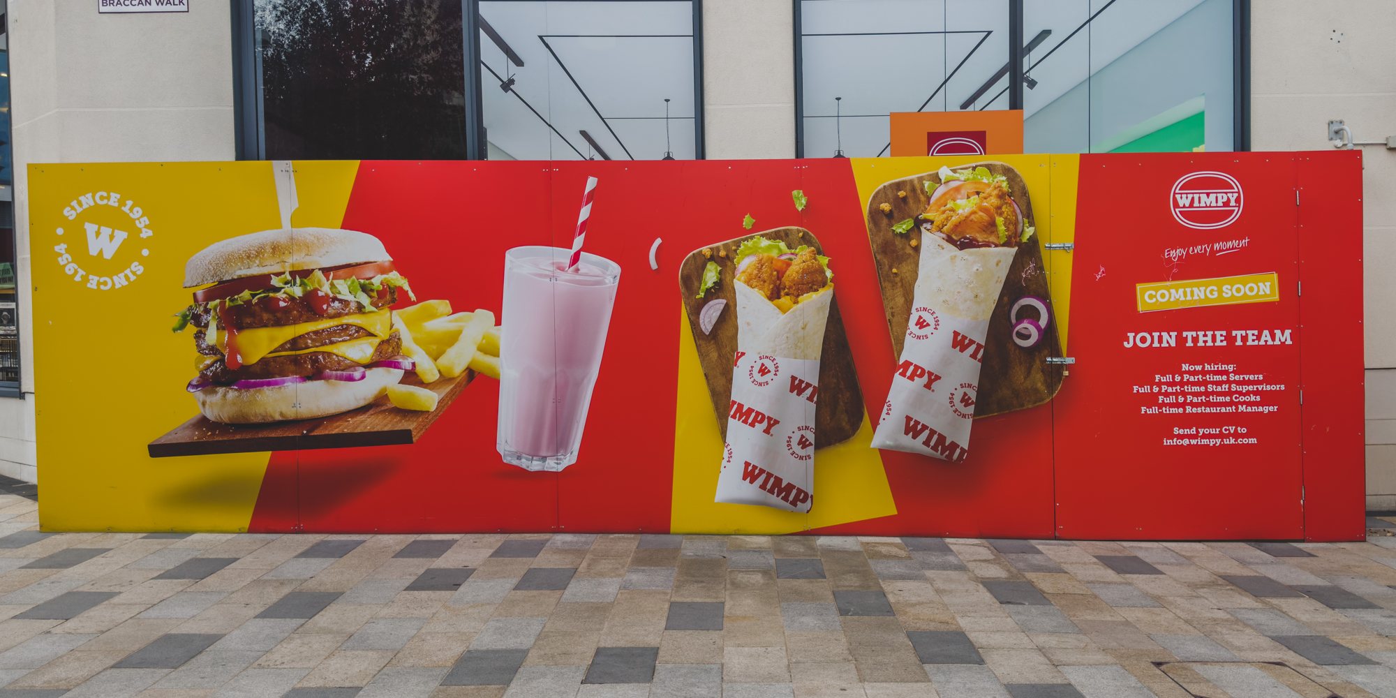 Printed WIMPY coming soon hoarding along the storefront in Bracknell